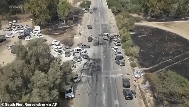 Charred and damaged cars line a desert road after an attack by Hamas militants on the Tribe of Nova Trance music festival near Kibbutz Re'im in southern Israel on Saturday, October 7