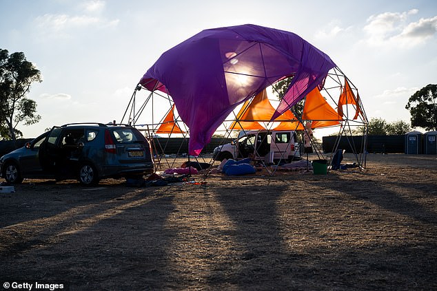 Destroyed cars and personal belongings are still strewn across the festival grounds, pictured on October 13