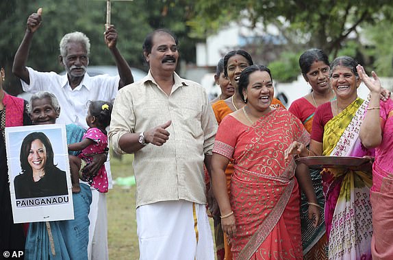 Villagers celebrate the victory of U.S. Vice President-elect Kamala Harris in Painganadu, a village neighboring Thulasendrapuram, the birthplace of Harris' maternal grandfather, south of Chennai, Tamil Nadu state, India, Sunday, Nov. 8, 2020. Waking up to the news of Kamala Harris' selection as Joe Biden's running mate, overjoyed people in her Indian grandfather's hometown set off fireworks, carry her banners and pray. (AP Photo/Aijaz Rahi)