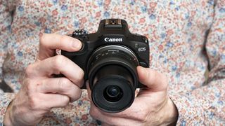 Canon EOS R100 camera in hand