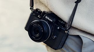 Nikon Zf with Z 40mm F2 lens attached to a strap on the photographer's waist