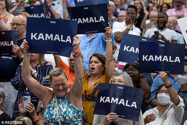 People hold up signs in support of U.S. Vice President Kamala Harris as she speaks during a campaign rally at West Allis High School in West Allis, Wisconsin, on July 23