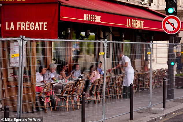 Locals were seen eating at a restaurant behind a fence in Paris, which is used as a first line of defense