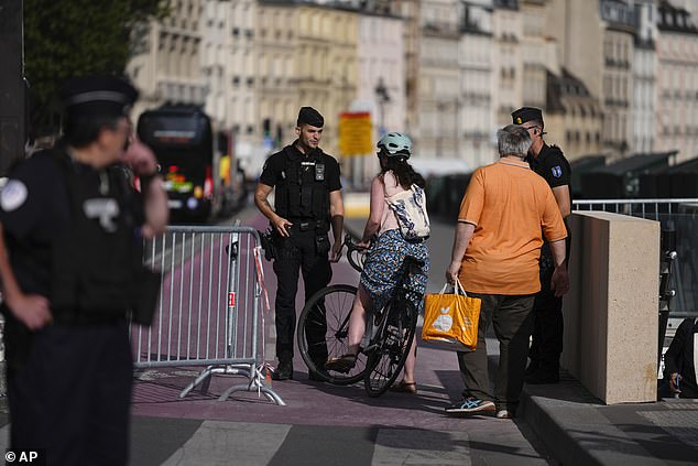 Police officers control access to roads near the Seine in preparation for the 2024 Summer Olympics