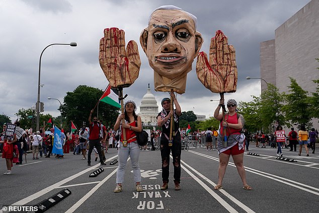 Pro-Palestinian protesters carry an image of Israeli Prime Minister Benjamin Netanyahu during a protest on the day of Netanyahu's speech