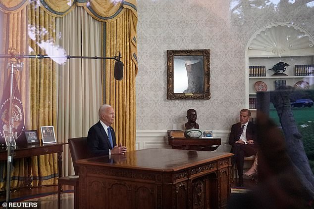 US President Joe Biden delivers an address to the nation about his decision to end his re-election campaign, from the Oval Office of the White House, as his son Hunter Biden listens, in Washington, DC