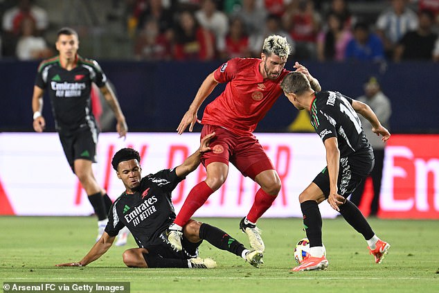 Arsenal's Oleksandr Zinchenko #35 and Leandro Trossard #19 fight for the ball