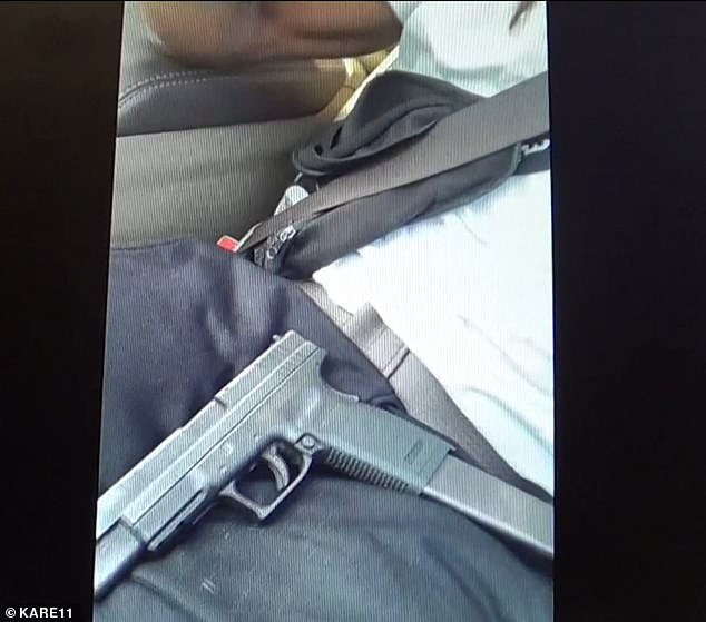 Another view of the gun on Smith's lap in the car during the video