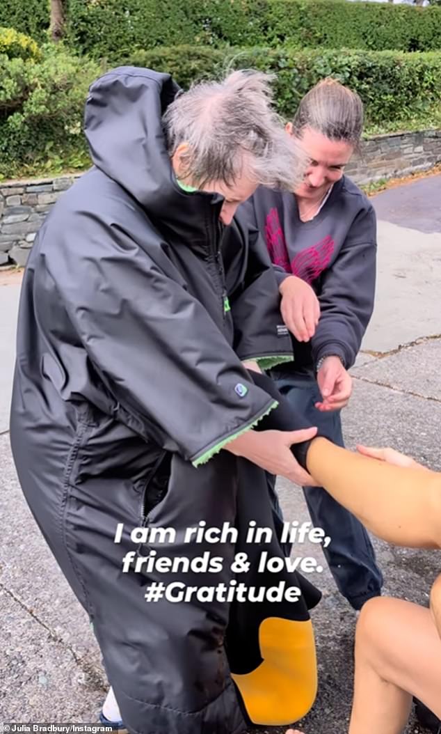 Julia wrote in the caption: 'I couldn't put on or take off my beautiful sustainable @finisterre wetsuit without my friends'