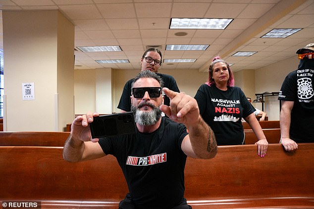 Jon Minadeo II, leader of the Goyim Defense League, makes hate gestures while disrupting a city council meeting in Nashville