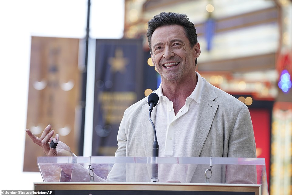 Jackman looked typically handsome as he took to the stage - showing off a bandaged finger