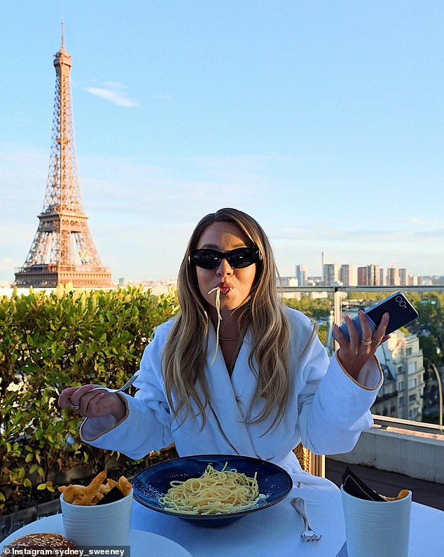 In one photo, the blonde beauty is seen enjoying a bowl of pasta and fries while sitting in front of the Iron Lady and holding her phone