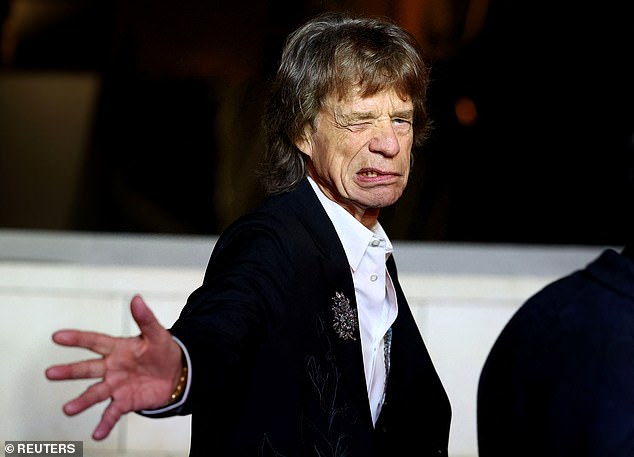 Mick pulled funny faces and extended his hand theatrically as he graced the event's dark green carpet