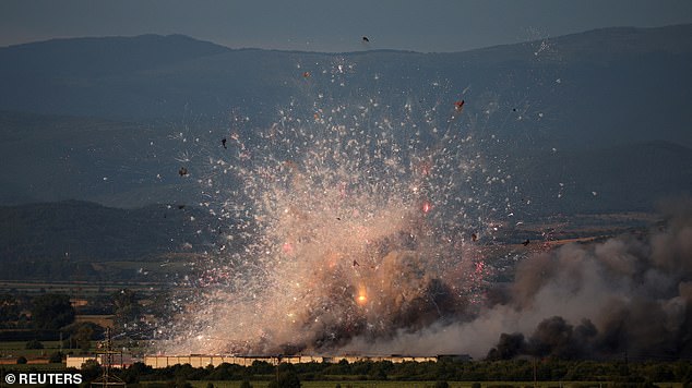 Video footage captured by local media shows a huge plume of smoke rising through the air as the bright lights of fireworks illuminate it.