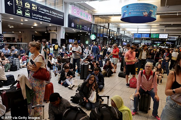 Passengers wait for their train at Gare Montparnasse train station in Paris on July 26, 2024, as France's high-speed rail network is hit by malicious acts that disrupt the transportation system.