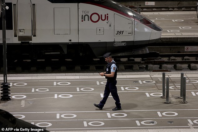 A French gendarme walks on a platform near an InOui TGV high-speed train at Gare Montparnasse train station in Paris on July 26, 2024