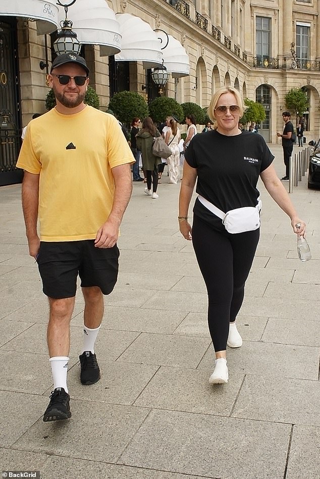 The Australian star, 44, opted for comfy black leggings and a stylish white bum bag as she was spotted alongside a male friend