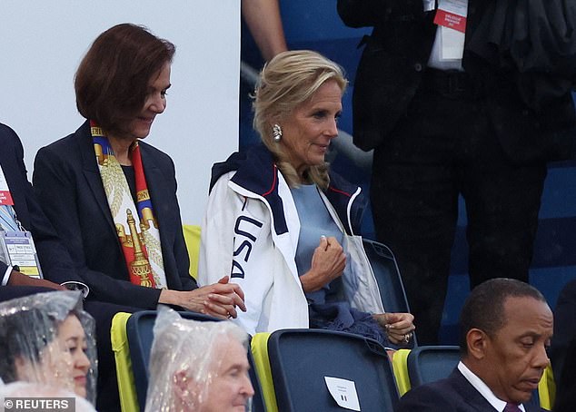 Jill Biden wears a US Olympic jacket during the rain in Paris, US Ambassador to France Denise Campbell Bauer is at left