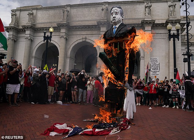 Pro-Palestinian protesters burn an American flag and an image of Israeli Prime Minister Benjamin Netanyahu on Wednesday