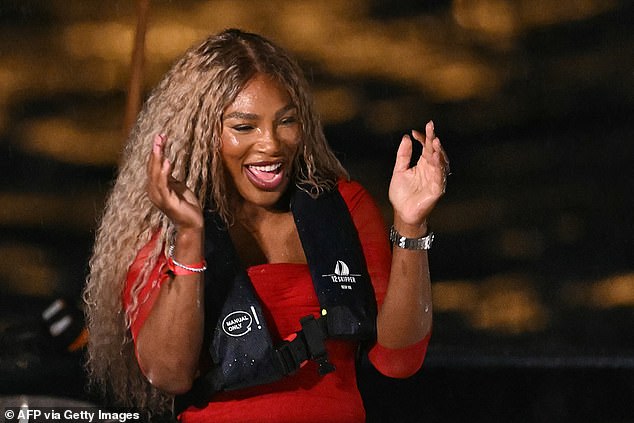 Serena Williams smiles and looks happy before being presented with the Olympic torch for the opening ceremony