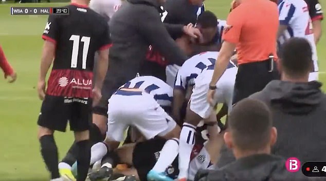 West Brom and Mallorca players try to separate the pair as they fall to the ground fighting