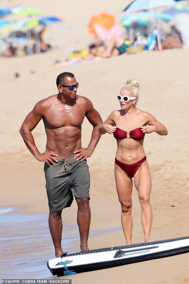 The couple looked muscular as they walked along the beach in Sardinia