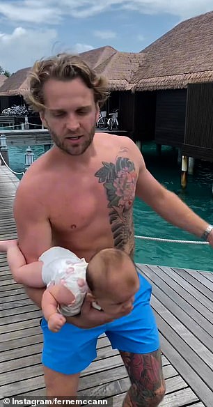 In another clip, Lorri carried baby Finty around on his arm while on vacation