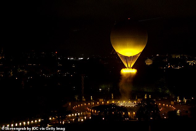 The Olympic flame floats into the sky on a golden globe