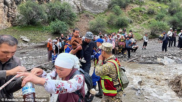 More than a dozen people have died in recent months from floods and landslides in Kyrgyzstan. Pictured: People are evacuated to safety by search and rescue teams after heavy rains hit the country