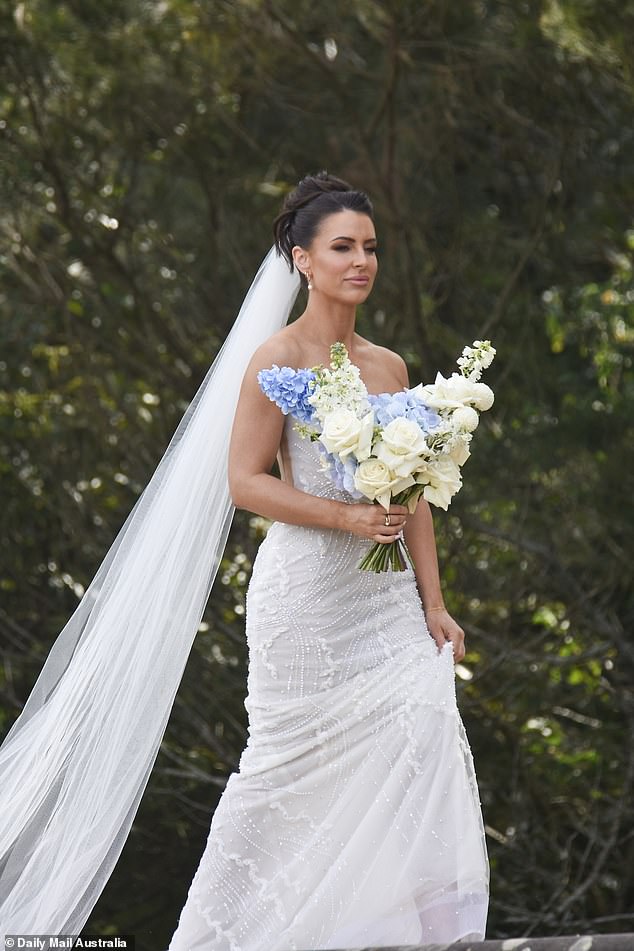 She wore her brunette locks pinned up in a stylish updo, while her long veil fanned out behind her as she looked ready for her big moment.