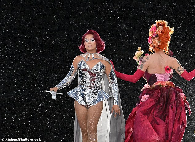 Drag Race France host Nicky Doll walks down the catwalk in the pouring rain during last night's opening ceremony