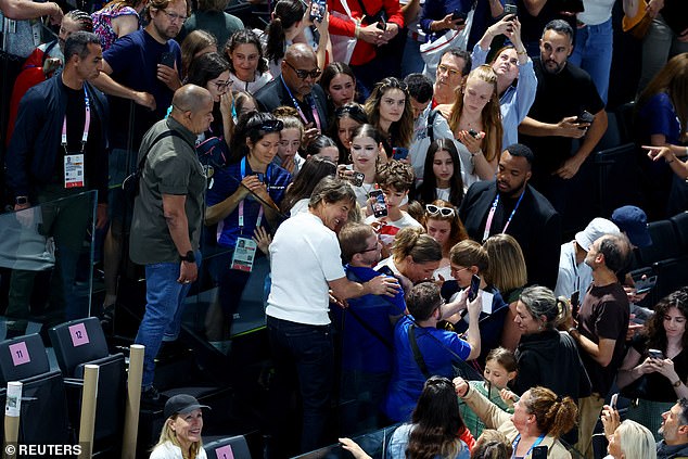 The Mission Impossible star was escorted to his seat by security as he paused to pose for selfies with several fans