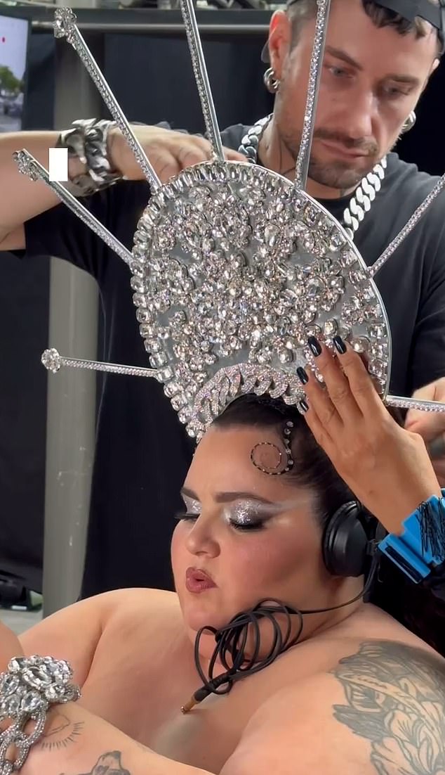 Barbara Butch is pictured getting ready for her performance as stylists put the striking headpieces into place