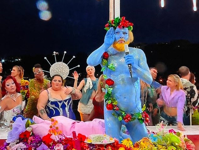 A performer, painted blue and covered with flowers and fruit, representing the Greek god Dionysus, sang in French