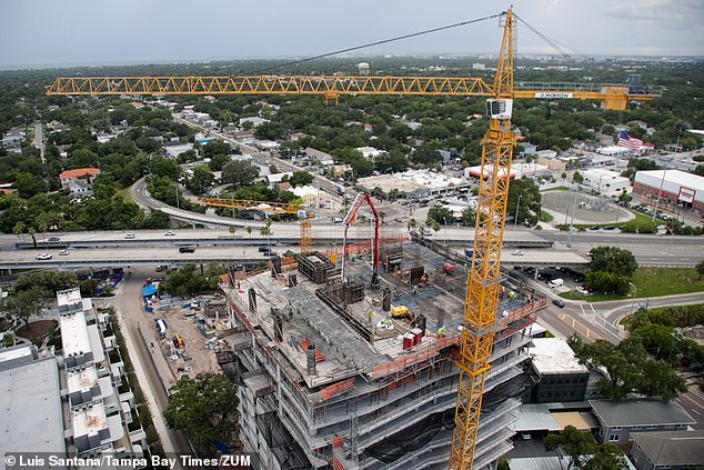 The Florida city's stable inflation figures are thanks to the region's booming economic development and housing construction. (Pictured: Construction workers work on Tower II of The Ritz-Carlton Residences on July 17)