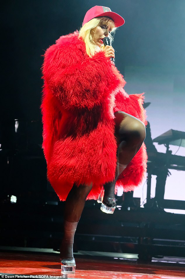 She completed her stage outfit with a huge feather coat and strutted her stuff in a pair of clear plexiglass heels