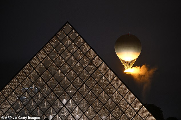 The cauldron, containing the burning Olympic flame, rises while attached to a balloon