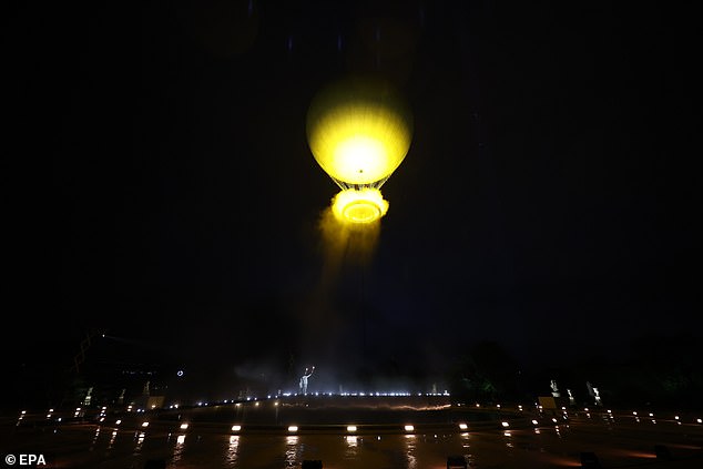 The cauldron containing the Olympic flame floats above La Concorde during the opening ceremony