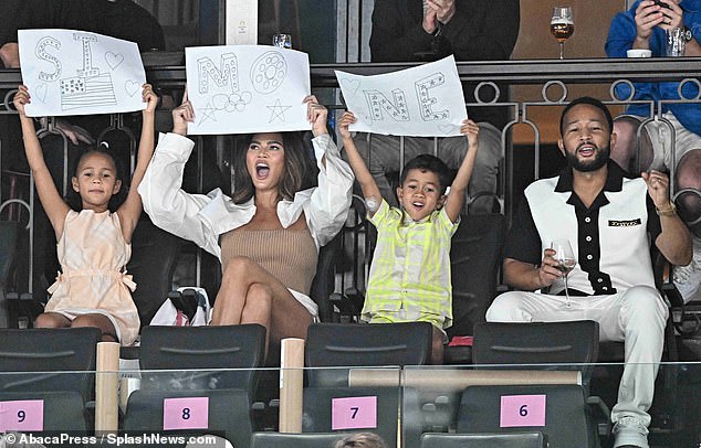 Chrissy and her little ones held up handmade signs in support of gymnast Simone Biles