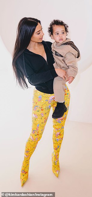 In several photos, Kardashian is seen wearing yellow patterned leggings and a black zip-up hoodie as she holds Tatum on her hip