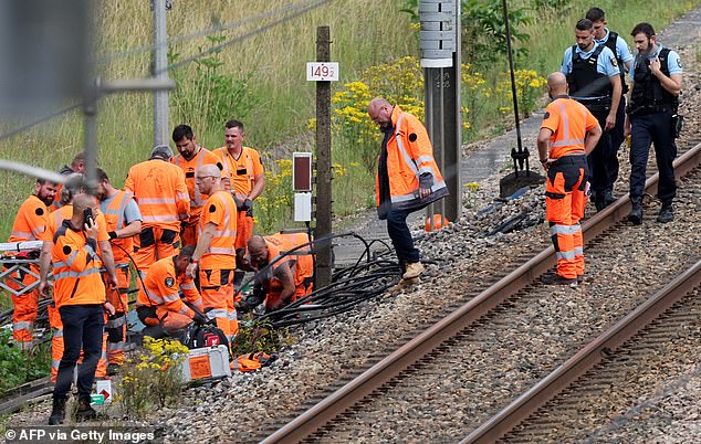 SNCF employees and French gendarmes inspect the scene of a suspected attack on the high-speed rail network in Croiselles, northern France on July 26, 2024