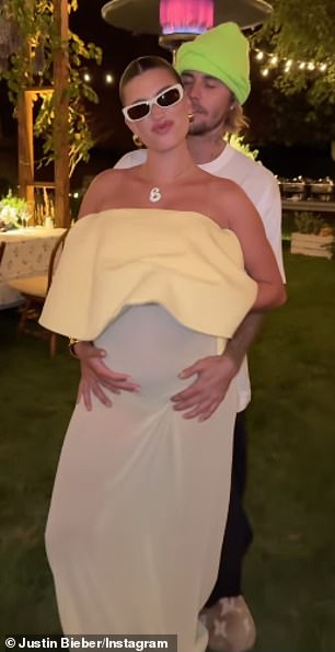 The runway model, who is currently expecting her first child with Justin, showed off her massive baby bump in an elegant white evening gown during an al fresco dinner