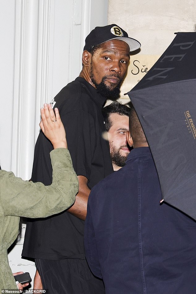 Kevin Durant wears a Boston Bruins cap as he heads out of Siena