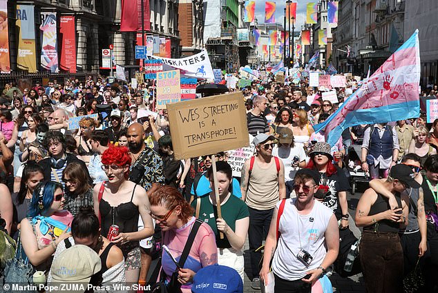 A protester at a Trans Pride march in London on July 27 holds a sign calling Health and Social Care Secretary Wes Streeting a transphobe