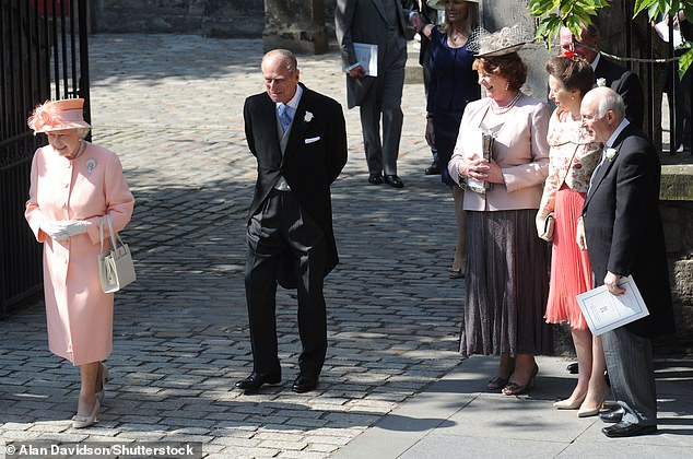 The Queen and Prince Philip pictured walking past the bride and groom's parents