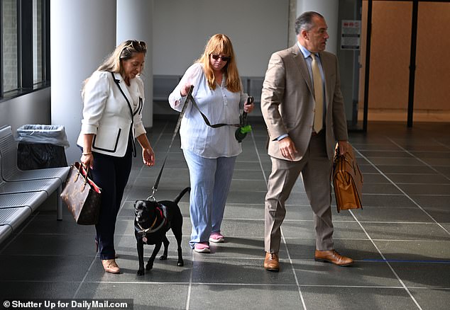 Ellerup looks at her support animal with her lawyer and another member of the legal team at her side, minutes before they enter the courtroom