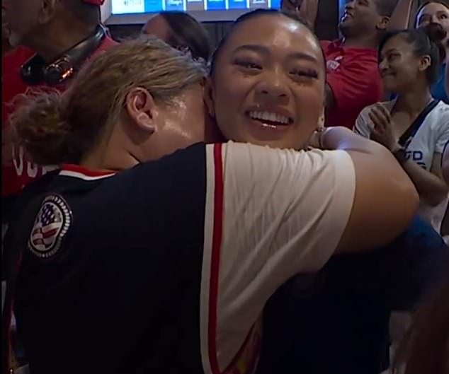 Suni Lee is hugged by her mother after they are reunited following the gold medal