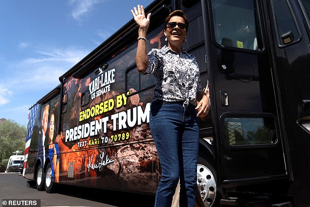 Lake greets members of the press before casting her vote at Paradise Valley City Hall during the Arizona state primary.