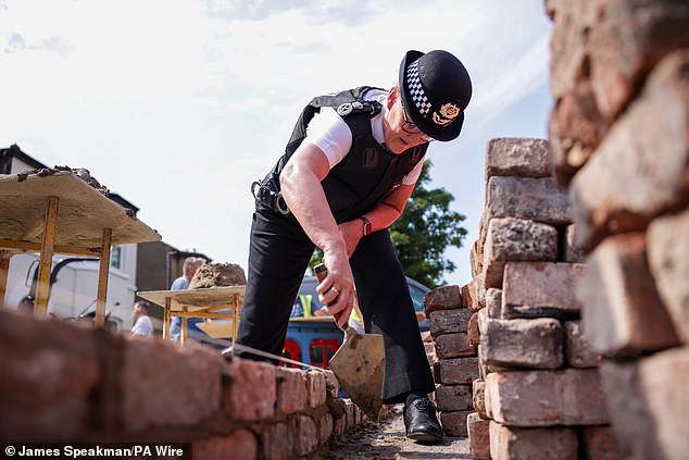 She was seen helping to repair a wall that had been destroyed by rioters, who used the bricks as missiles against officers