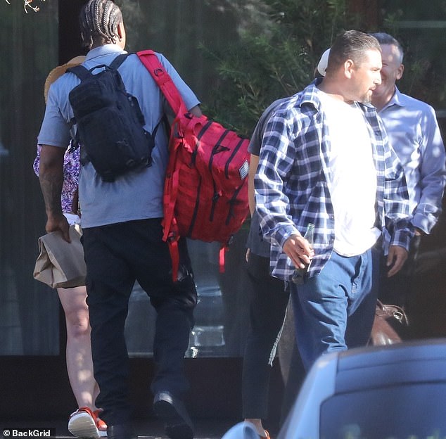 Paul opted for a wide white tee with a blue and white checked shirt on top, complemented with jeans and sneakers